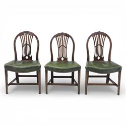 George III style set of six mahogany dining chairs, the arched backs with pierced and carved vase splats beneath carved husk and patera detail, drop-in upholstered seats covered in green leather with brass studded edging, raised on square section legs united by plain stretchers