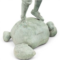 After Eneri Prosperi, bronze garden child statues, depicting children balancing on rock-form bases, the boy in shirt and shorts, the girl in dress with raised arms, surrounded by loose rounded pebble elements