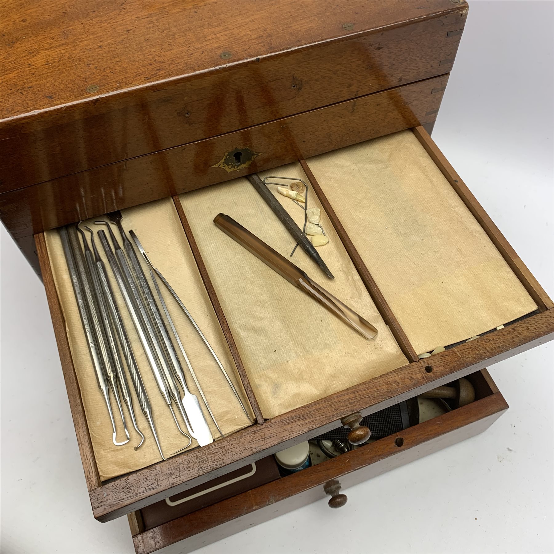  Dentistry - Late Victorian mahogany Dentists cabinet by C. Ash & Co, hinged cover above six long graduated drawers, enclosing a comprehensive arrangement of implements, pharmaceutical bottles, tools, modelling wax, porcelain teeth, 