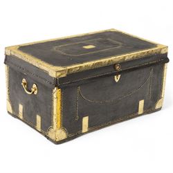 An early 19th-century Georgian brass-bound travelling trunk, leather-covered exterior with brass stud work decoration, front with central brass lock plate, hinged lid with camphor wood interior, external sides fitted with large brass carrying handles 