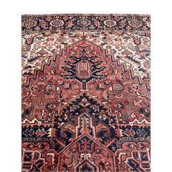 Persian Heriz red ground carpet, large stylised pole medallion surrounded by Pitrak motifs, indigo ground border decorated with stylised flower heads and trailing leafy branches, within floral pattern guard stripes