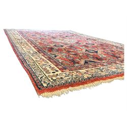 Pair of rugs one Persian hamadan rug central stepped medallion enclosing geometric motifs in ivory and brown, framed by a cream border with scrolling palmettes and fringed ends (H 156cm W 105cm), one Pakistani Bokhara rug rust red ground with repeated Tekke gul motifs within rosette and lozenged borders, fringed ends (H 98cm, W 65cm)