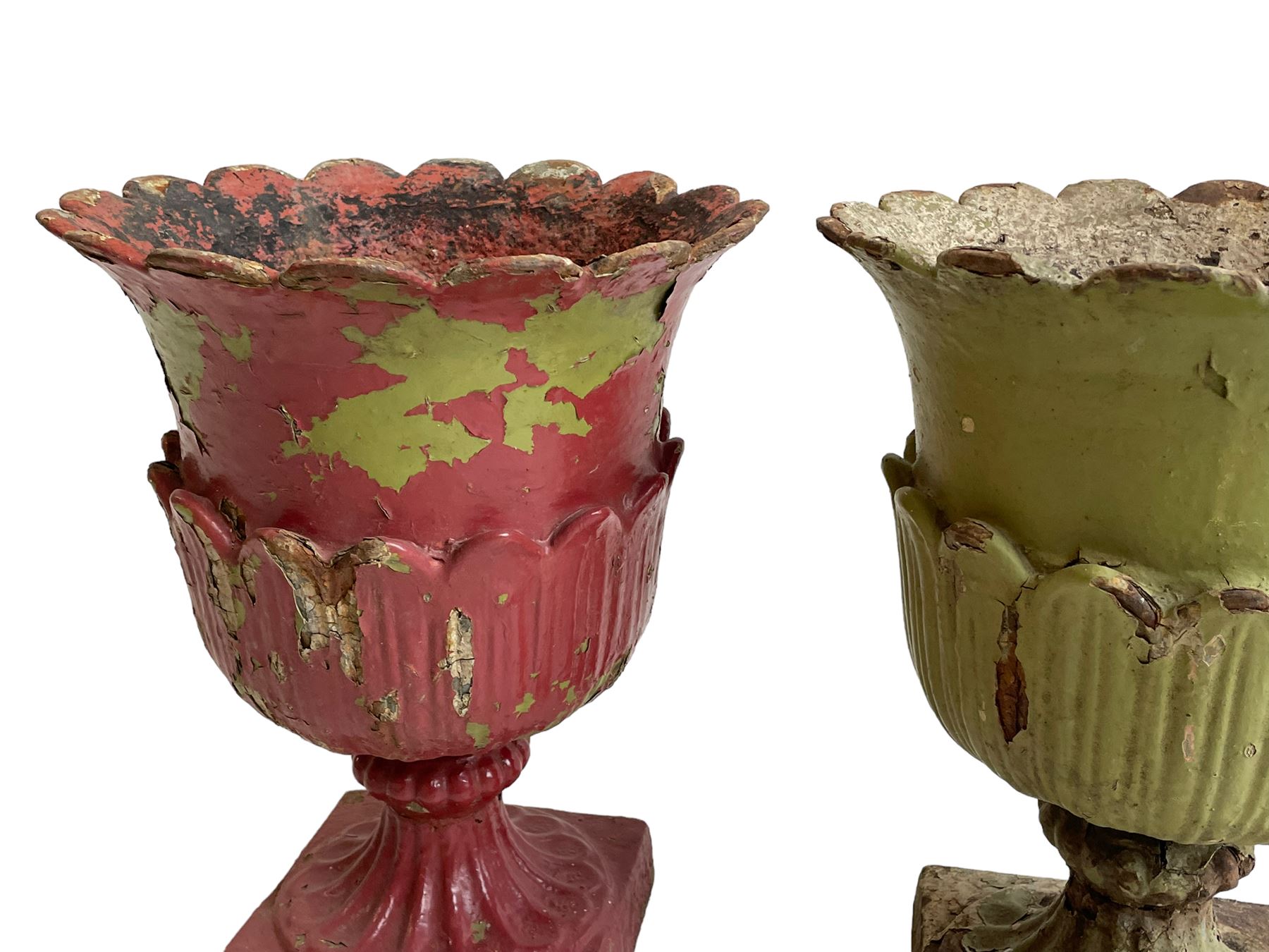 Pair of Victorian cast iron lotus garden urns, the shaped rim over lappet cast underbelly, on moulded footed base