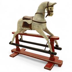 20th century carved and painted rocking horse, with original dappled paint finish, studded leather saddle and reins, on later red and black swing frame