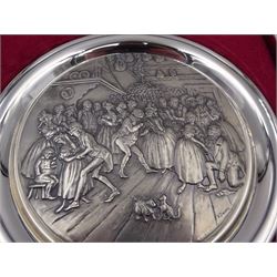 Modern silver 'The Birmingham Mint 1975 Christmas Plate', of circular form, embossed to the centre with a scene of merriment and dancing, hallmarked Birmingham Mint, Sheffield 1975, contained in fitted glazed case, plate D20cm