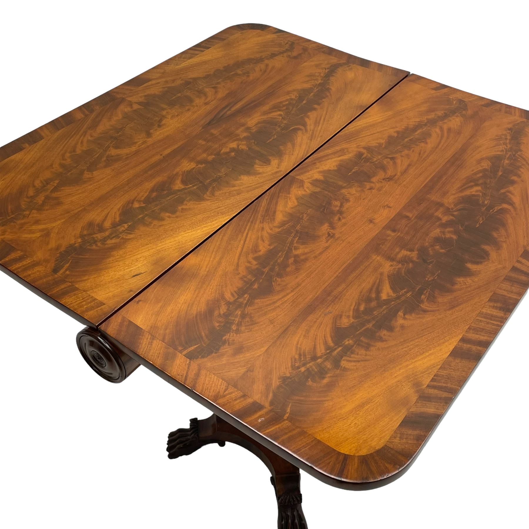 Unusual William IV mahogany Sutherland table, figured and book-matched rectangular drop-leaf top on cylindrical barrel movement, turned roundels to each end, on turned pedestal with acanthus carved baluster, shaped platform with four extended paw feet