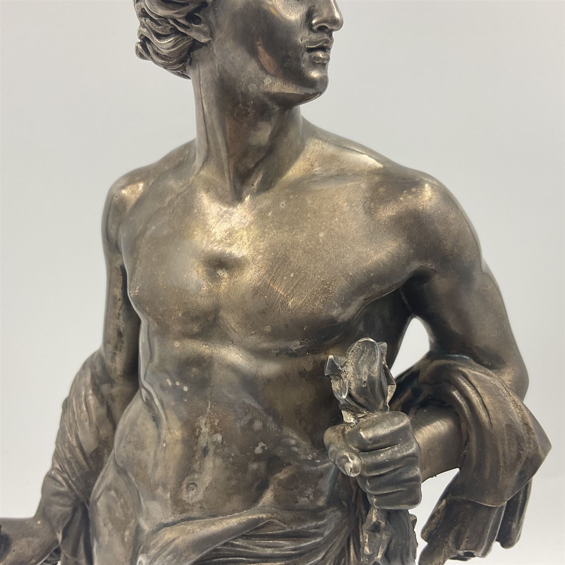 20th century silver plated figure, modelled as a classical male figure, possibly Prometheus, holding flames, one foot resting atop a small dragon, upon a circular spreading base, overall H37.5cm