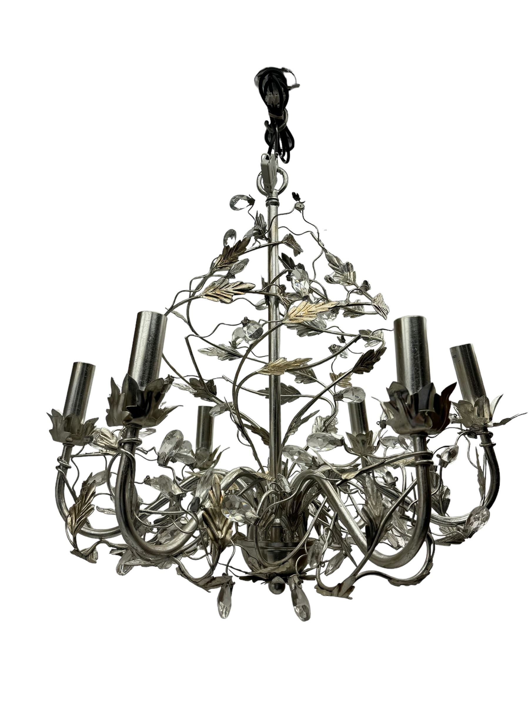 India Jane - silver finish metal chandelier, modelled with scrolling vines and leaves, embellished with faceted glass drops, fitted with six candle sconces, and wired for electricity