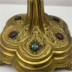 20th century gilt metal monstrance, in the Gothic revival style, with glazed aperture to centre surrounded with clear paste stones, in a pierced floral and scroll border set with coloured paste stones, within a sunburst surround, on a paste set knopped stem and similar foliate foot, H59.3cm