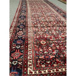 Persian red ground rug, the field decorated with Herati motifs, repeating guarded border