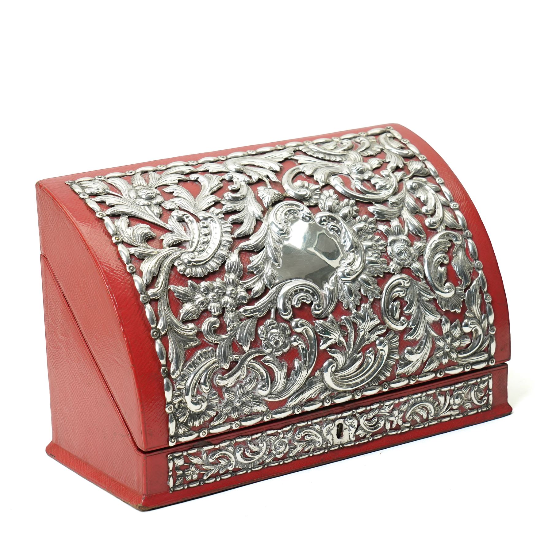 Late Victorian red leather stationery casket with divided watered silk interior, the hinged front with repousse silver mounts H19cm x W30cm London 1889 Maker William Comyns