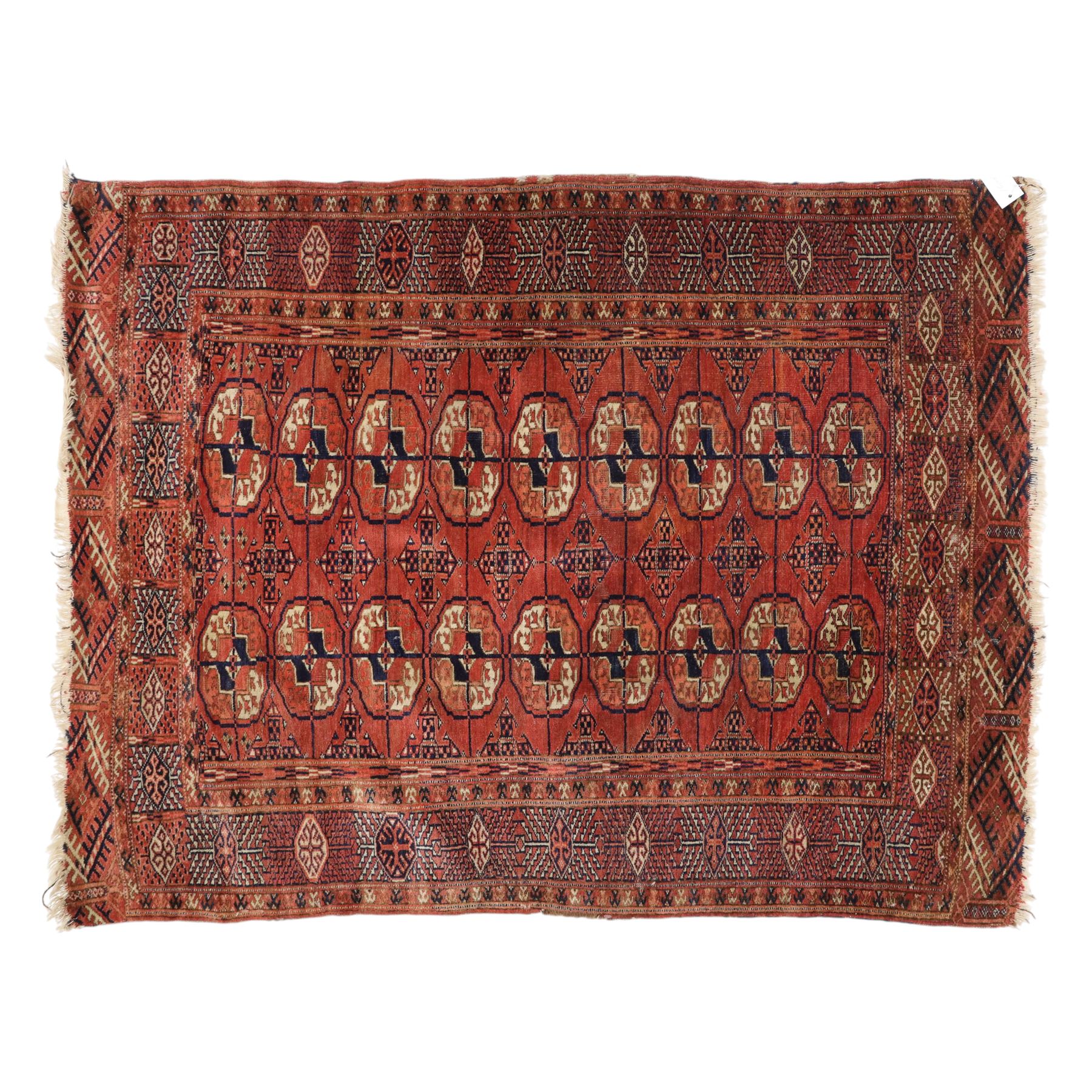 Central Asian Turkmen Tekke hand-knotted rug, madder red field decorated with rows of octagonal guls linked by secondary motifs within a dense geometric border, with fringe ends  