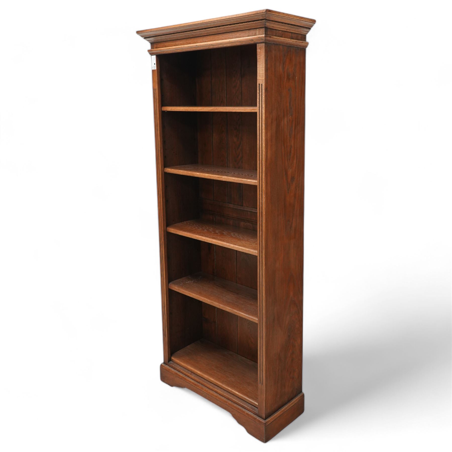 Oak open bookcase, projecting cornice over open front fitted with adjustable shelves, fluted uprights, on shaped bracket feet 