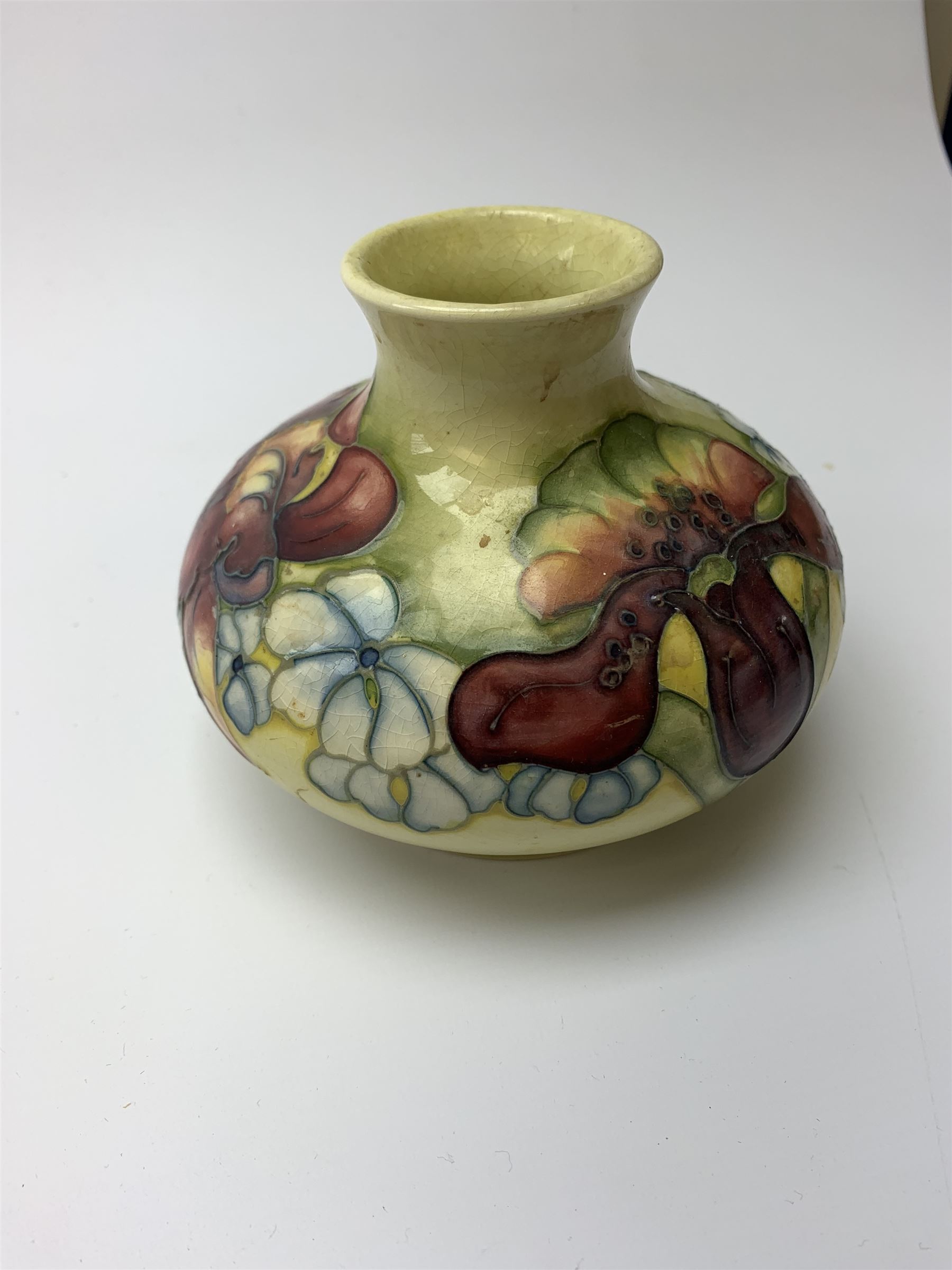 A Moorcroft vase, circa 1950, of squat bulbous form, decorated in the Orchid pattern upon a yellow glazed ground, with impressed and blue painted WM initials for Walter Moorcroft, H10.5cm. 