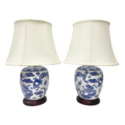 Pair of table lamps of baluster form, decorated with decorated with dragons chasing flaming pearls amongst clouds, on circular footed base, including shades H55cm