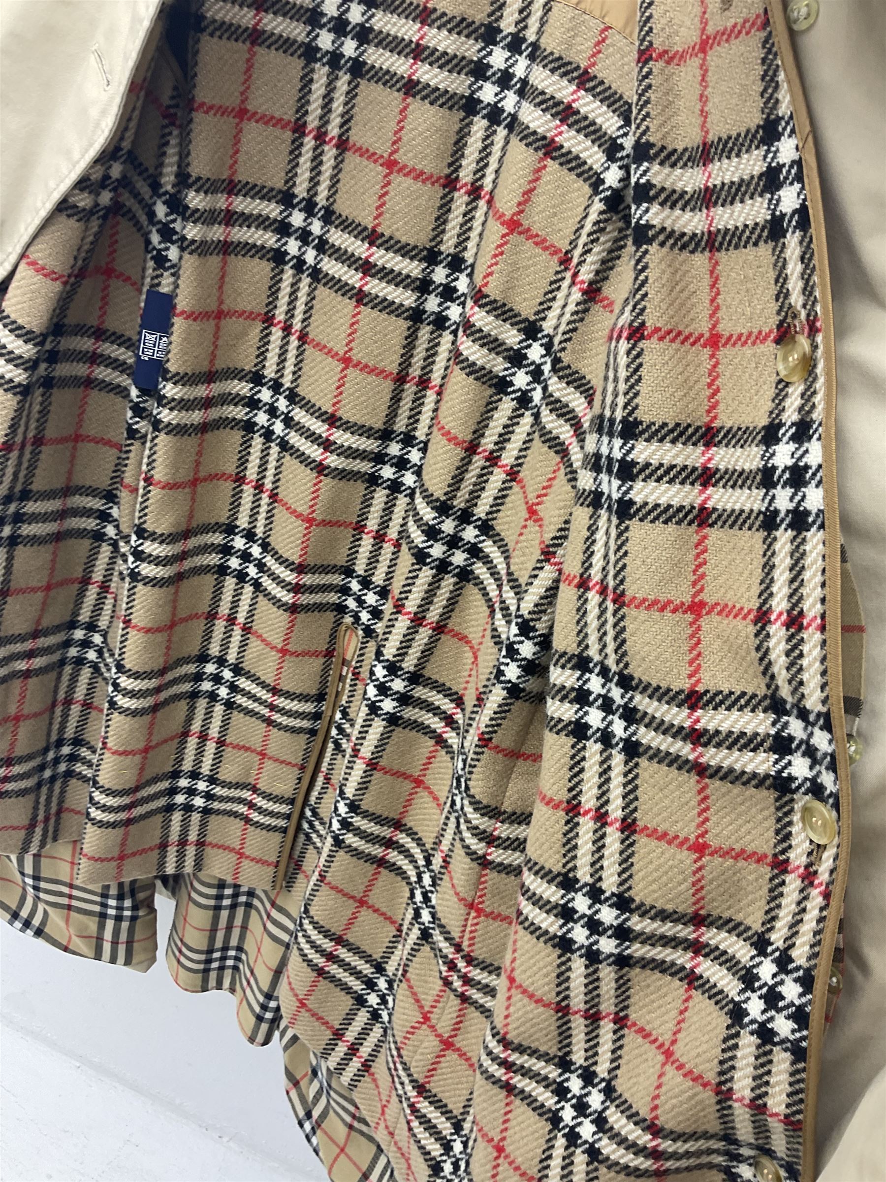 Ladies Burberry double breasted trench coat, with belt and detachable woollen gilet, in traditional cream colour with Burberry check lining, together with a gentlemans Burberry single breasted trench coat, both L112cm