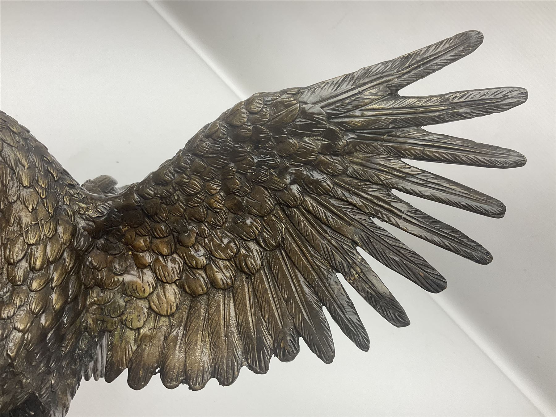 Bronze eagle, modelled in a standing position with wings spread, raised on a black veined marble circular plinth base, H29cm