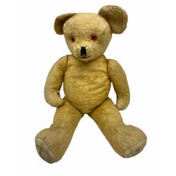 Large mid-20th century English plush covered teddy bear, the revolving head with applied eyes, vertically stitched nose and mouth and jointed limbs H64cm; another long-haired teddy bear with wood wool filling; a smaller part wood wool filled teddy bear with blue eyes; and a small black teddy bear (4)