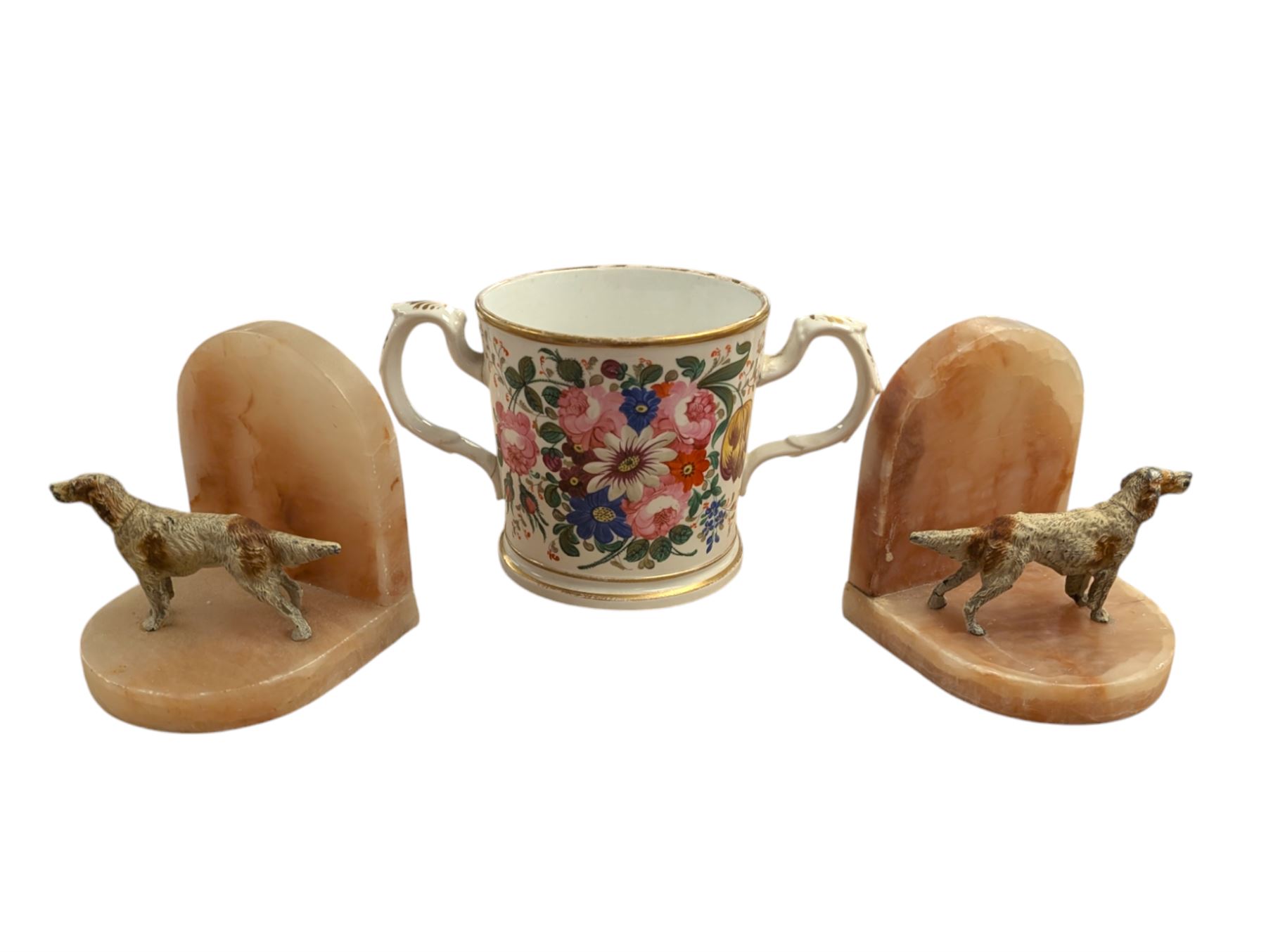 Pair of Art Deco dog bookends and a twin handled loving cup, painted with floral decoration and quote, loving cup H14cm
