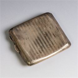 Two early 20th century silver cigarette cases, comprising a rectangular example with foliate decoration and vacant shield cartouche and a 1920s example with engine turned decoration and engraved initials, both hallmarked