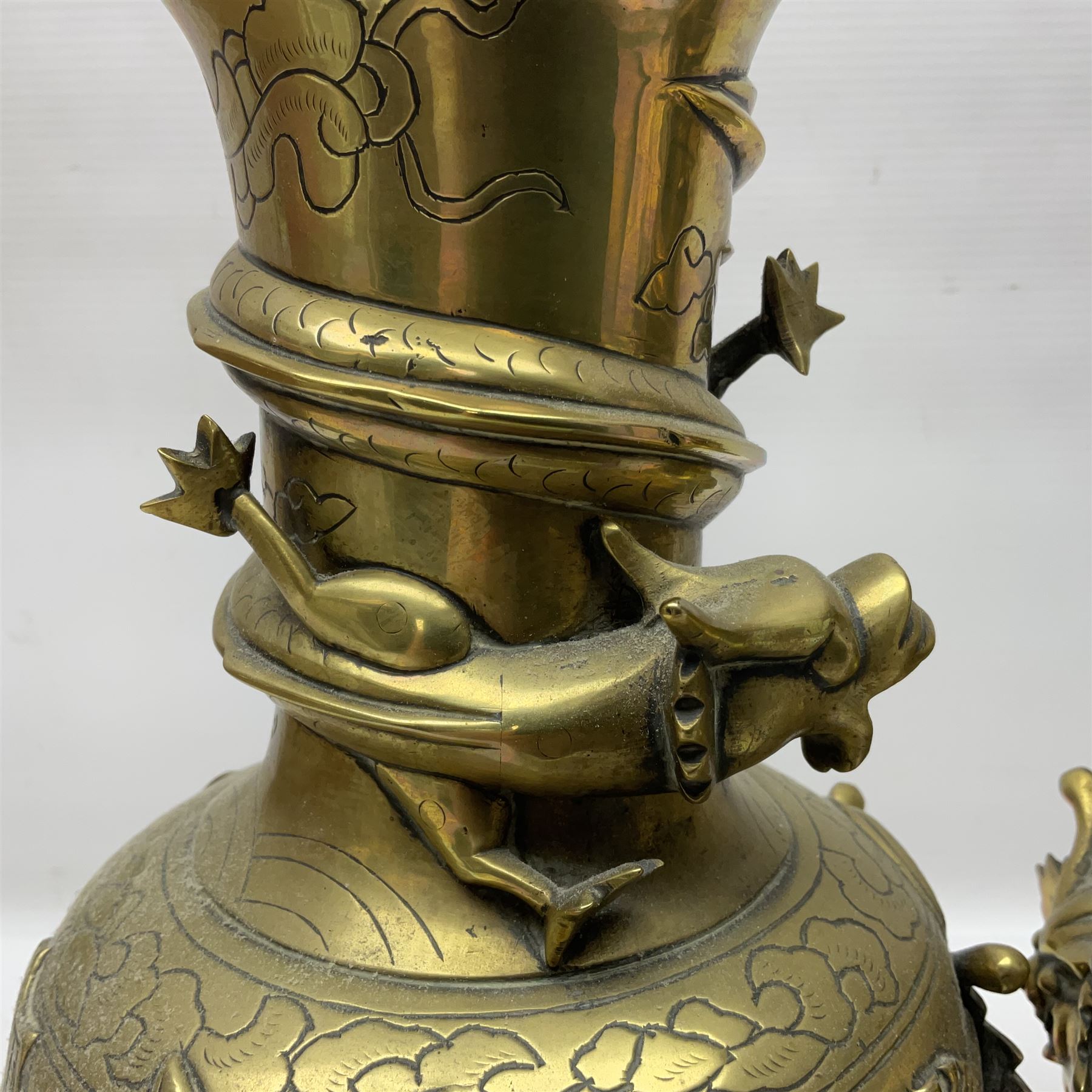 Pair of Chinese brass vases, of ovoid form with elongated neck and fluted rim, decorated in high relief with a dragon chasing a flaming pearl around the neck, the body with dragons, birds and buildings, with character marks beneath, H25cm