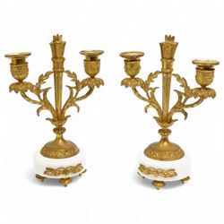 French-Ormolu and white marble mantle clock with garnitures, c 1910, with a white enamel dial and Arabic numerals, indistinct signature, pierced gilt-metal hands and minute markers, 8-day twin train countwheel striking movement, sounding the hours and half-hours on a bell, with a matching pair of two light candelabra. With pendulum and key.