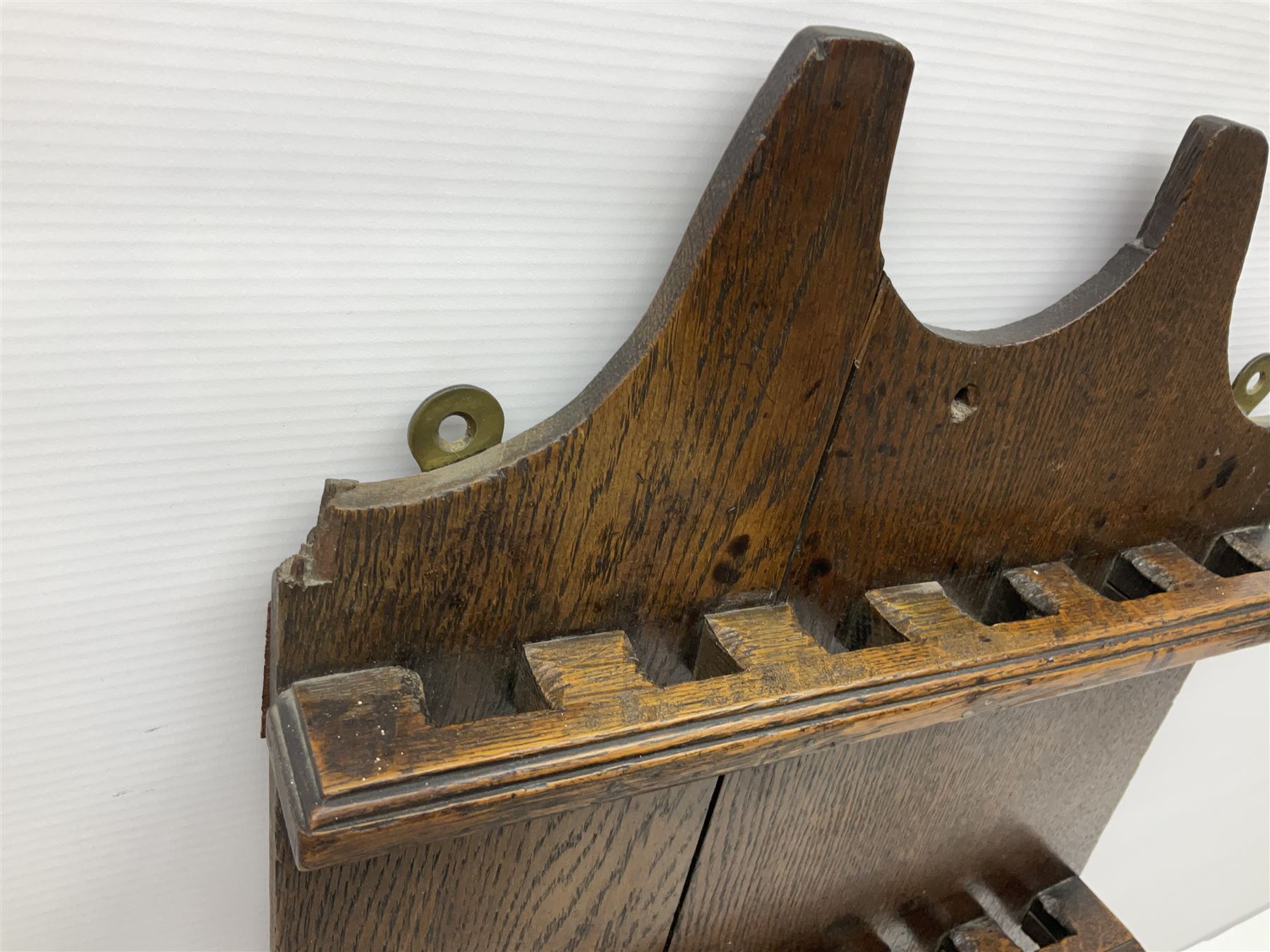 George III oak spoon rack and candle box, the rectangular backplate with shaped  pediment and two six aperture spoon racks, above a candlebox with hinged cover, with various brass spoons and a pair of brass candle snuffers, H56.5cm, W35cm, D14cm 