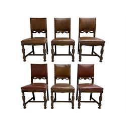 Set six Jacobean Revival oak dining chairs, back and sprung seat upholstered in tan leather with studwork border, back decorated with applied carved C-scrolls, raised on turned and carved baluster front supports united by H-stretcher