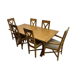 Solid oak dining table on x-framed supports, and six dining chairs 