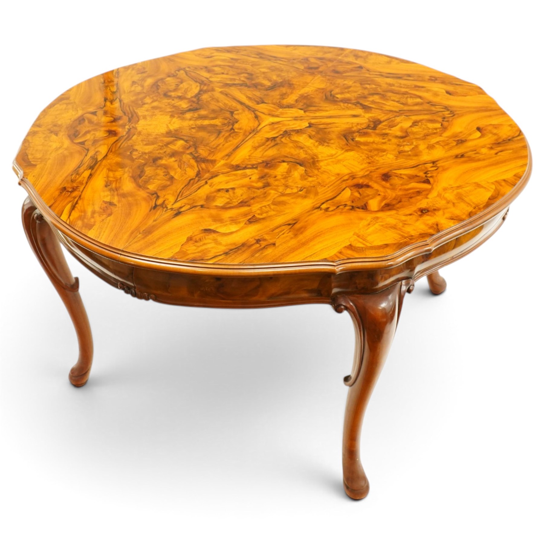 Dutch design figured walnut extending dining table, the shaped circular extending top with book-matched veneer and moulded edge, shaped banded frieze over scroll-moulded lower rail, raised on C-scroll carved cabriole supports with pad feet, with additional leaf