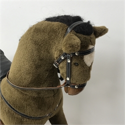 Rocking horse with leather saddle and reins on stained wooden trestle base