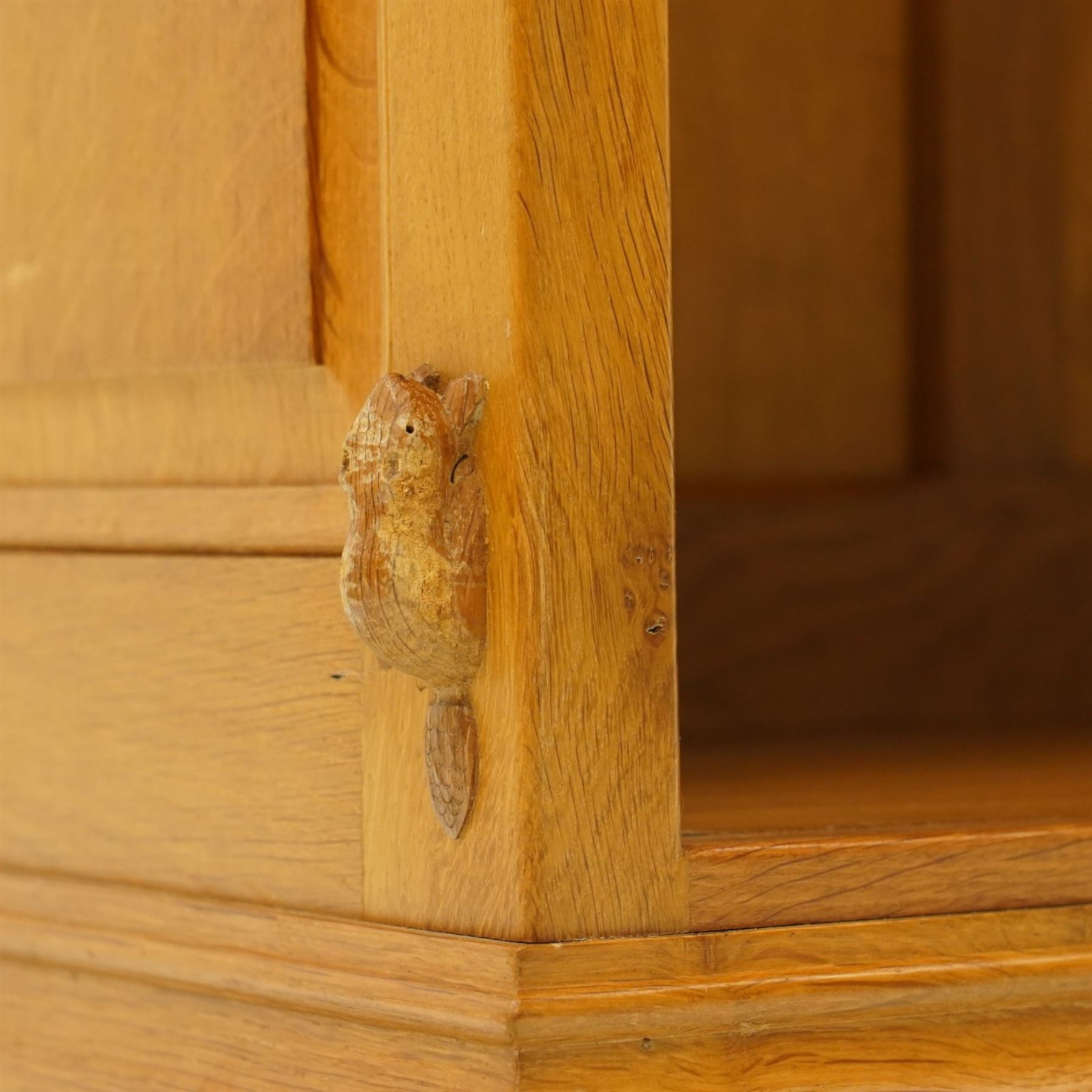 Beaverman -  Adzed oak open bookcase, with two sets of two adjustable shelves, panelled sides on a plinth base, with carved beaver signature, by Colin Almack of Sutton near Thirsk