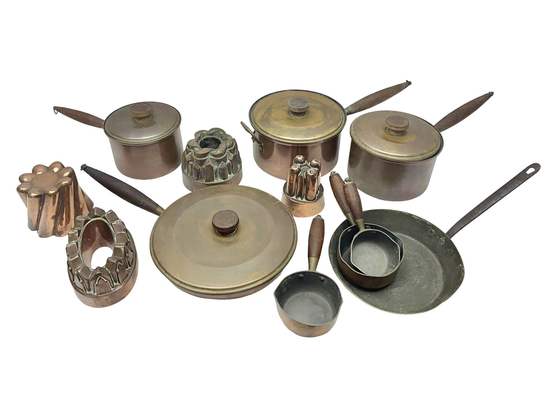 Four Victorian copper moulds, together with a graduating set of copper pans with wooden handles and finials to covers, largest pan 