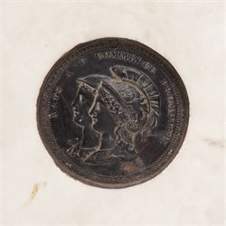 Composite plaque, depicting Sprites in a garden, with inset 'Arts and Commerce Promoted' medallion to reverse, 20cm x 33cm; together with a moulded glass Claret jug with silver plated mount H30cm 