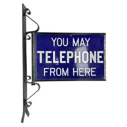 Double sided enamel sign, inscribed 'You may telephone from here' upon a hinged wrought-iron bracket, H72cm, L50cm