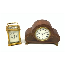 A brass cased carriage clock with carry handle, the white enamel dial with black Roman numerals, excluding handle H11cm, together with an Edwardian inlaid mantle clock, of lobed form raised upon four bracket feet, H14.5cm.