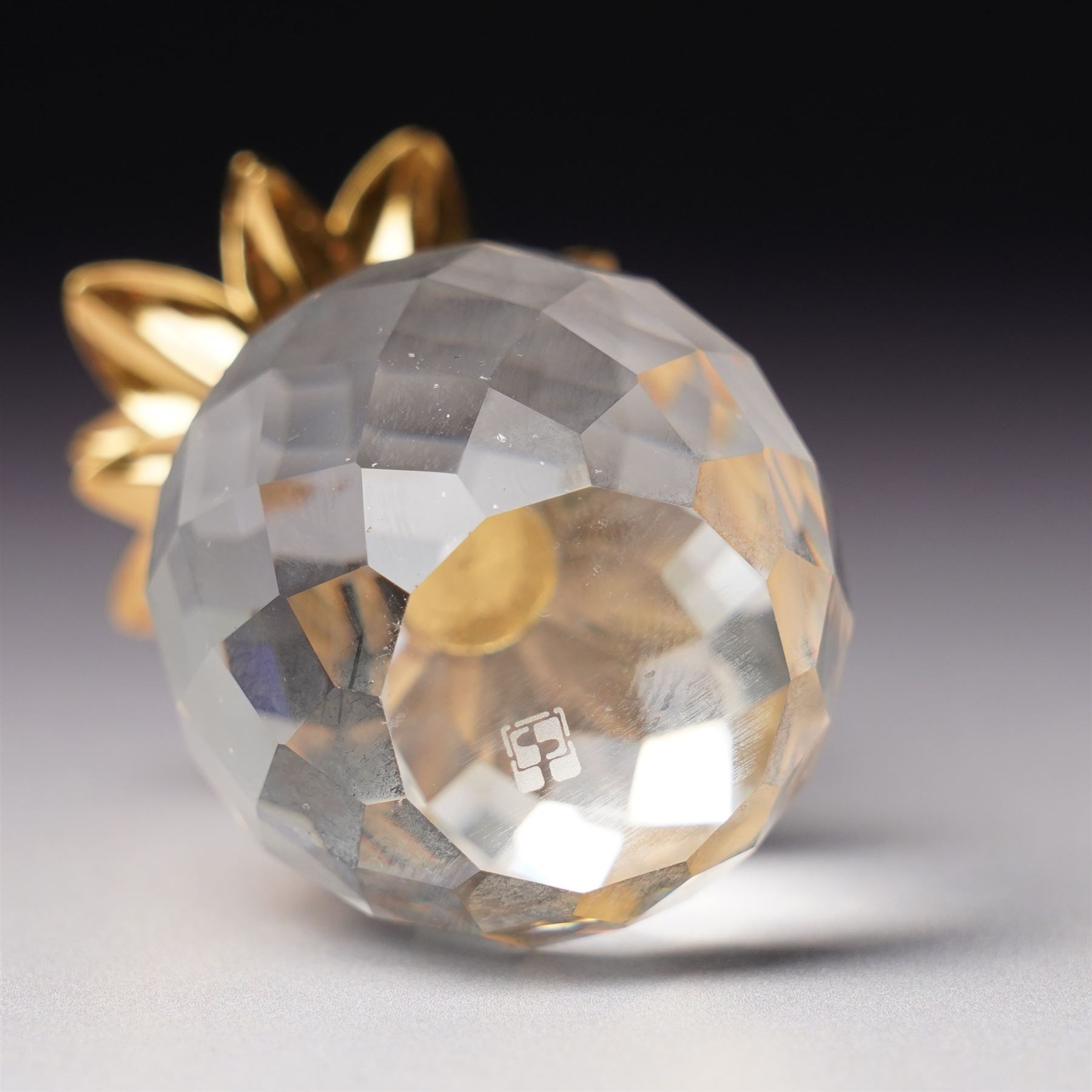 Pair of Swarovski Crystal candlesticks, boxed, together with two paperweights in the form of pineapples with gilt mounts, a large and small example, boxed (4)