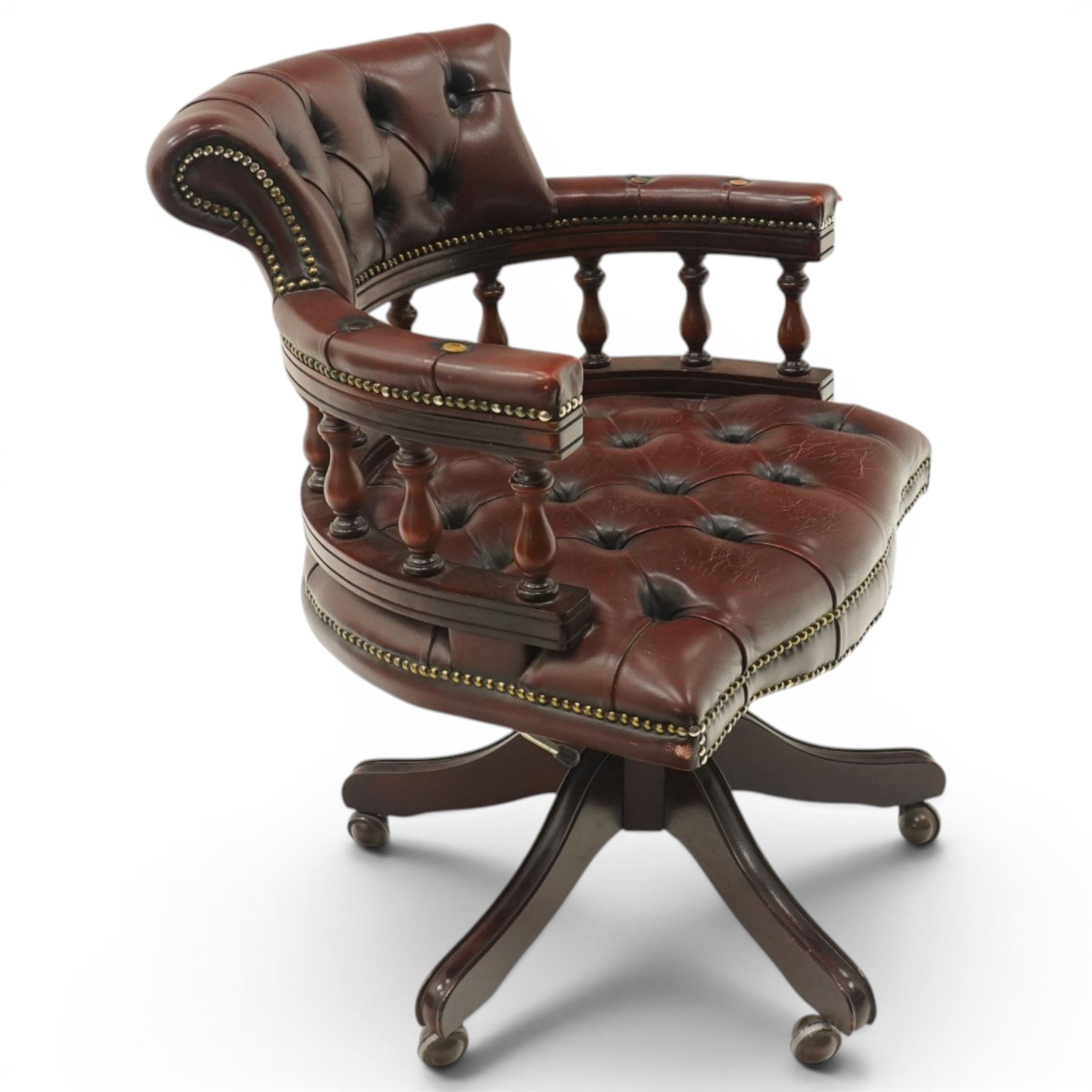 Georgian design captains swivel desk chair, rolled cresting rail over open spindle back on tripod base, upholstered in buttoned oxblood leather