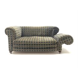 Early 20th century two seater drop arm sofa, upholstered in geometric pattern, turned supports and castors 