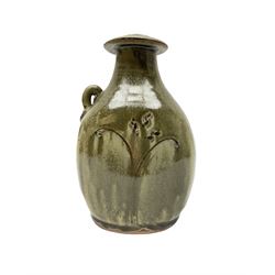Jim Malone (British 1946-): Stoneware flask with trailing green glaze, incised floral decoration and lug handle, unmarked H20cm 