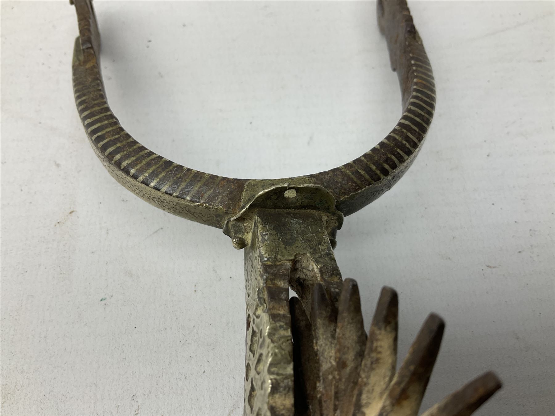 Pair of late 19th century South American iron spurs, engraved silver mounts, with sunburst rowls