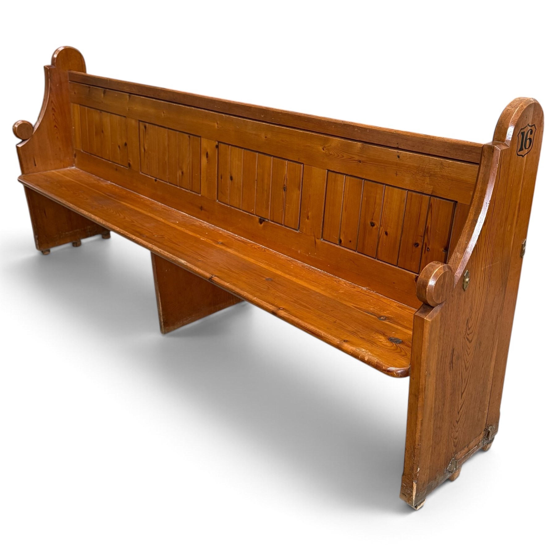 Early 20th century stained pine ecclesiastical church pew, the shaped end supports flanking slatted and panelled back, with black stencilled number '16' to the side