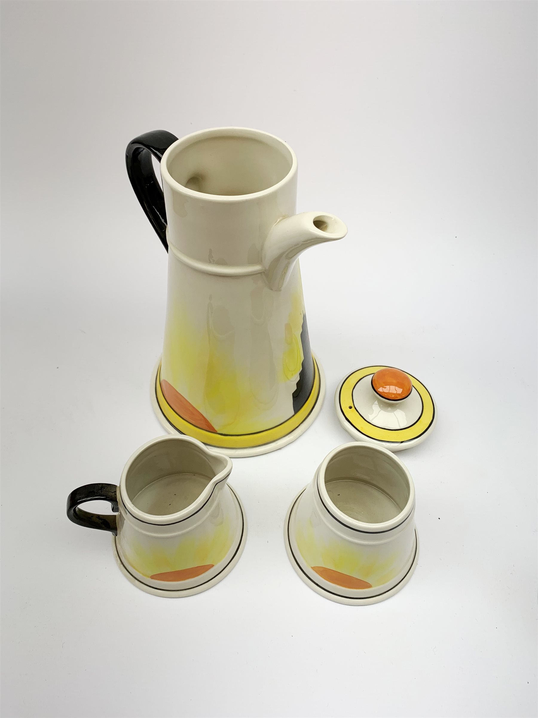 A Carlton Ware Art Deco style coffee set, decorated in the 'Manhatton Sunset' pattern, comprising coffee pot, milk jug, open sucrier, and six coffee cans, all of tapering form, coffee pot H26.5cm. 