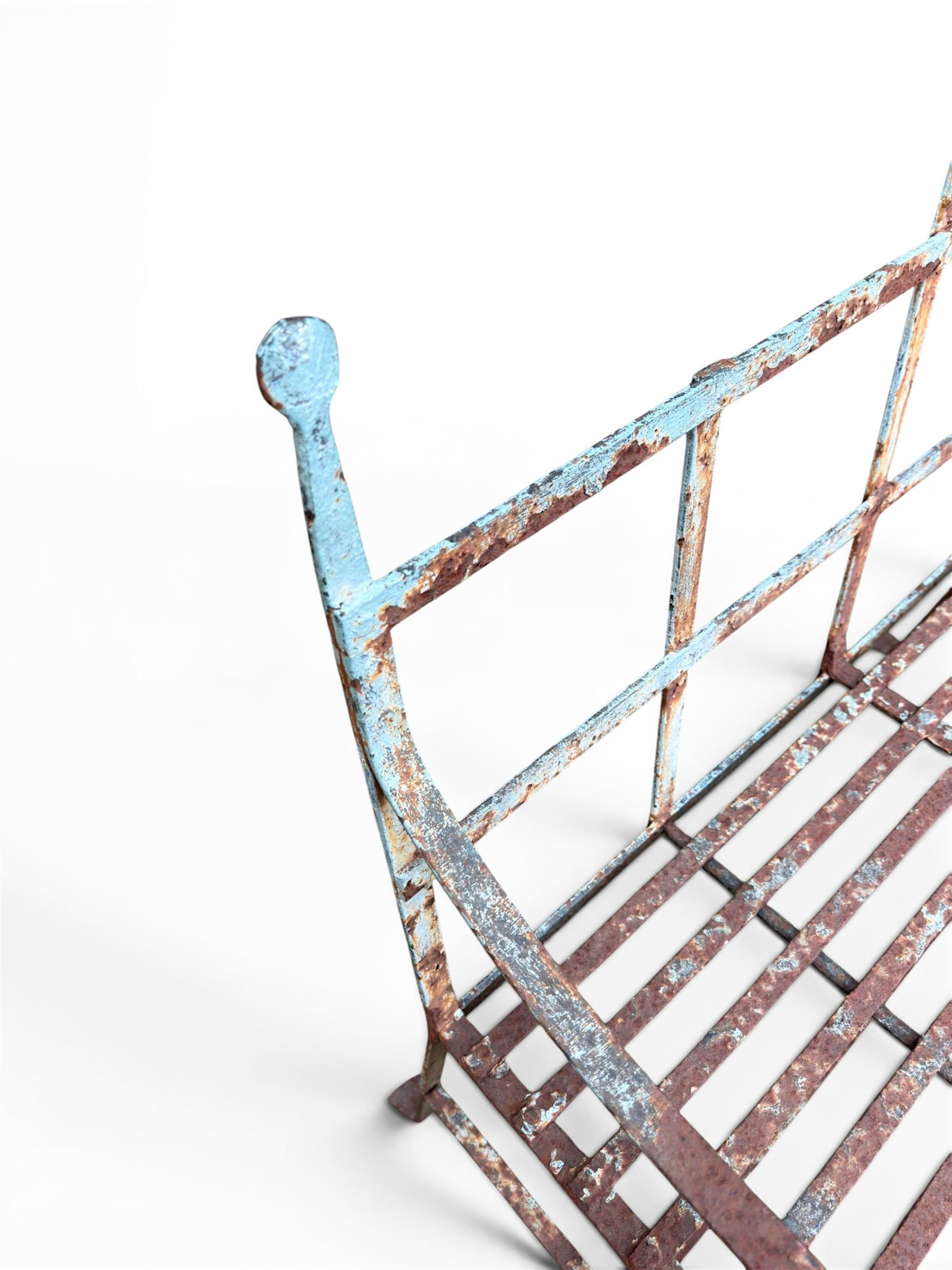 Regency period wrought iron strapwork garden bench, cresting rail with central Scottish thistle motif and flanking pediments, in distressed blue painted finish