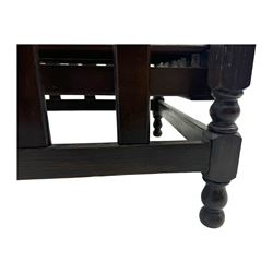 Late Victorian oak steamer chair, adjustable slatted backrest with grooved crest rail, wide armrests extending to a sliding adjustable footrest, open frame sides with vertical slats, side magazine rack and collapsible table, raised on turned front supports