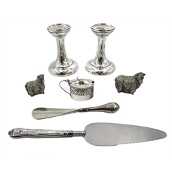 Pair of Edwardian silver dwarf candlesticks by George Unite, Birmingham 1907, silver mustard with glass liner by Henry Williamson Ltd, two silver filled sheep by Franklin Mint, silver handled cake slice and shoe horn