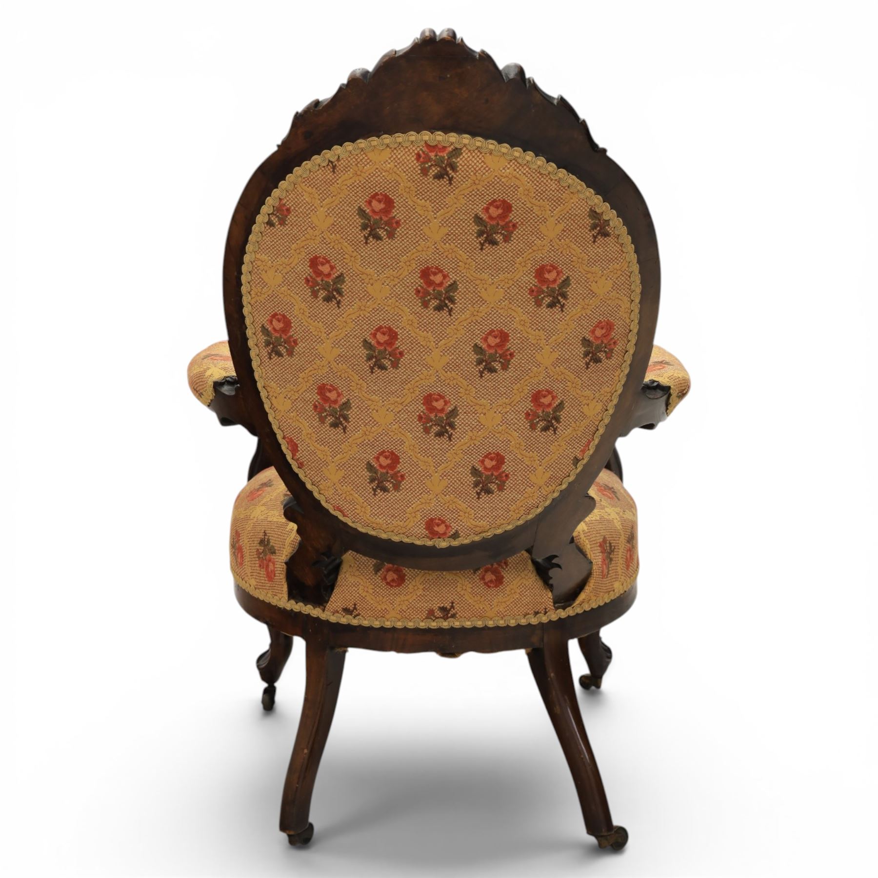 Victorian mahogany open armchair, oval stuff-over back with floral upholstery, moulded and foliate carved frame with pierced crest, padded open arms with scroll terminals, serpentine seat rail on cabriole supports