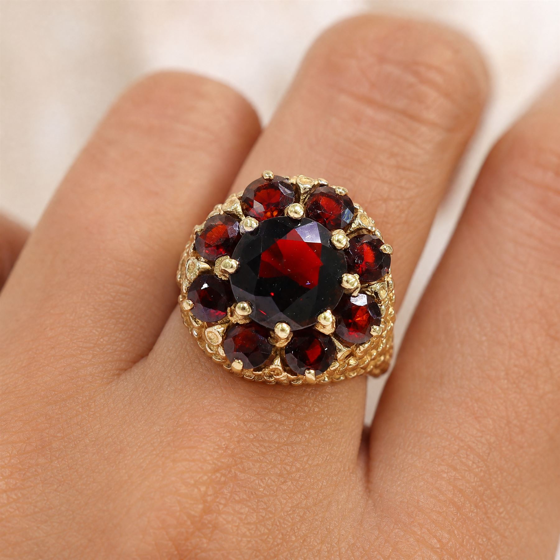 9ct gold garnet cluster ring, set with nine round cut garnets, with textured gallery and shoulders, hallmarked