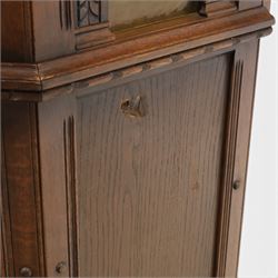 Old Charm - carved oak bar with three bar stools and associated Old Charm drinks cabinet, carved top with channels for glassware beneath, bar surface above glazed panels, shelves for glassware to the back, associated Old Charm drinks cabinet with fall front linenfold carving, above twin doors with shelved interior