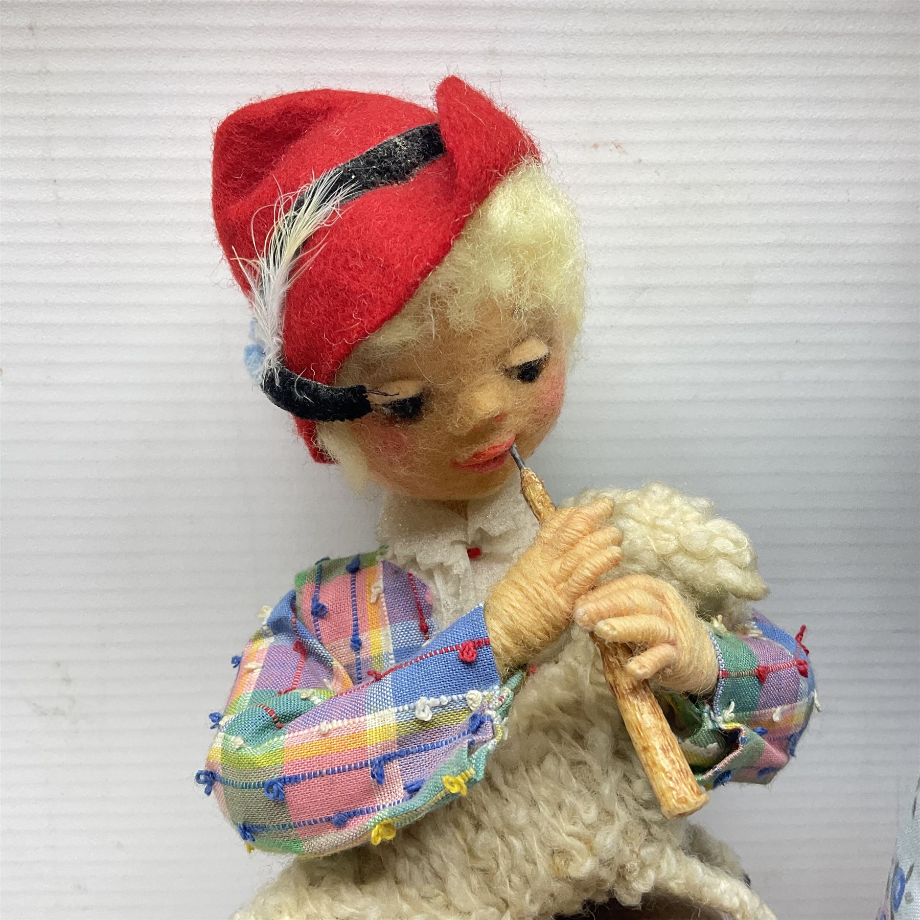 Anna Meszaros Hungary - five hand made needlework figurines including goose girl with stick H20cm; shepherdess in a sitting pose playing a penny whistle with a lamb on her knee; young girl holding a flowerpot; and two others (5)  Auctioneer's Note: Anna Meszaros came to England from her native Hungary in 1959 to marry an English businessman she met while demonstrating her art at the 1958 Brussels Exhibition. Shortly before she left for England she was awarded the title of Folk Artist Master by the Hungarian Government. Anna was a gifted painter of mainly portraits and sculptress before starting to make her figurines which are completely hand made and unique, each with a character and expression of its own. The hands, feet and face are sculptured by layering the material and pulling the features into place with needle and thread. She died in Hull in 1998.